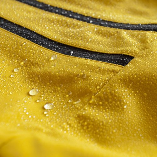 Beaded water on bright yellow performance material with water-resistant zippers.
